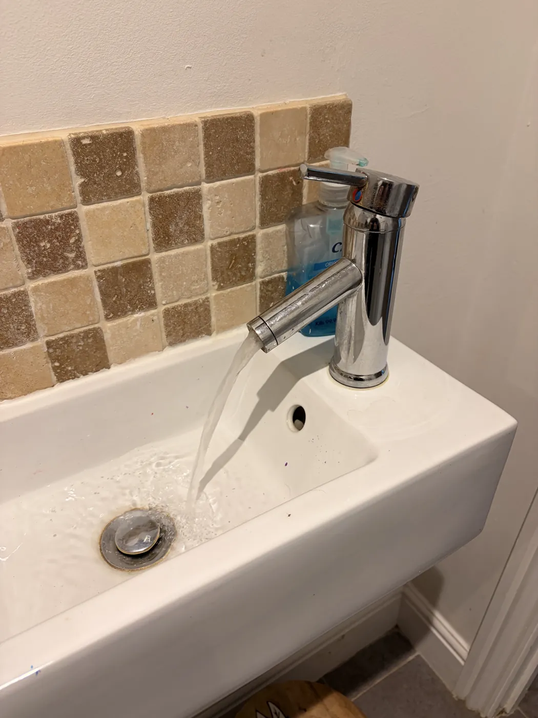A basin tap running after the water supply has been turned back on