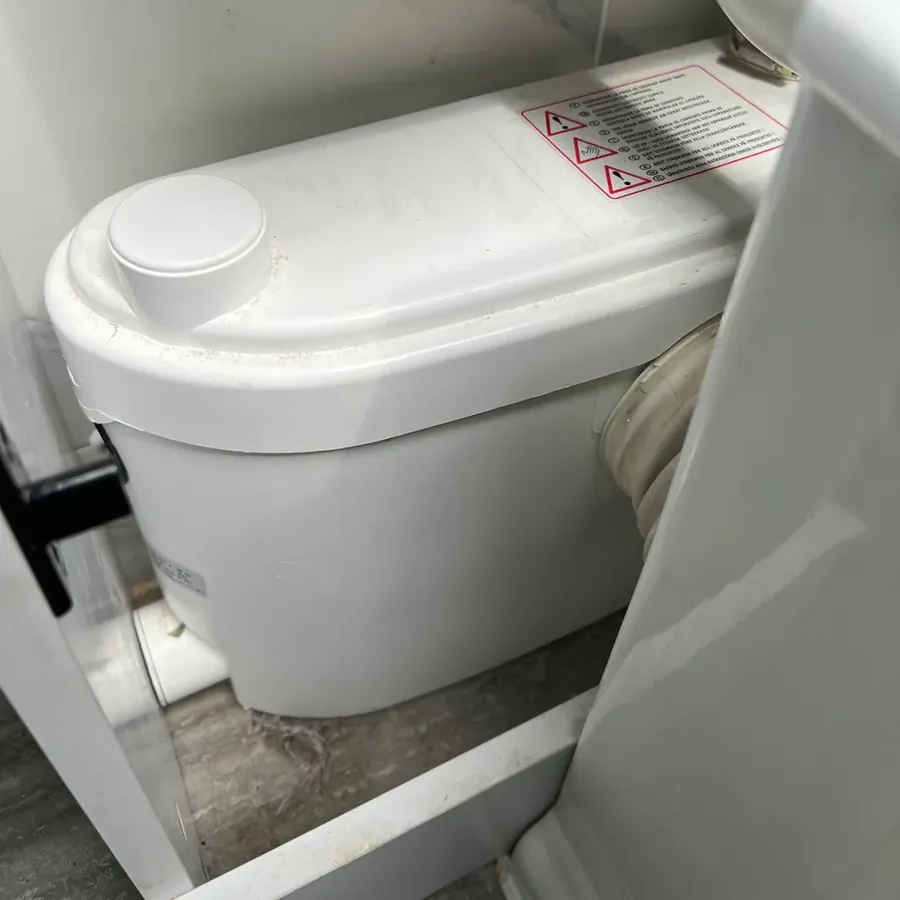 A Saniflo macerator behind a toilet