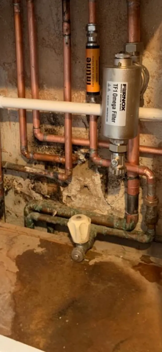 Water pooled under leaking heating pipework