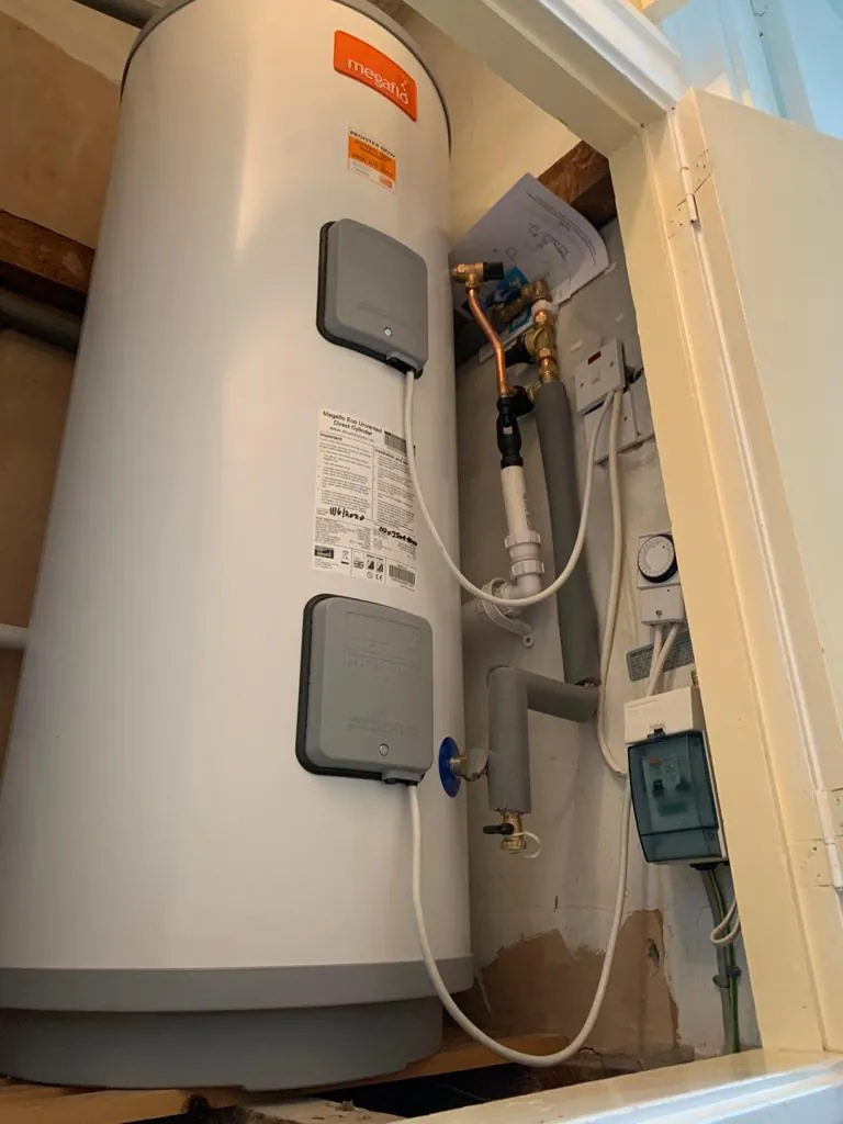 An unvented hot water cylinder fitted in a cupboard