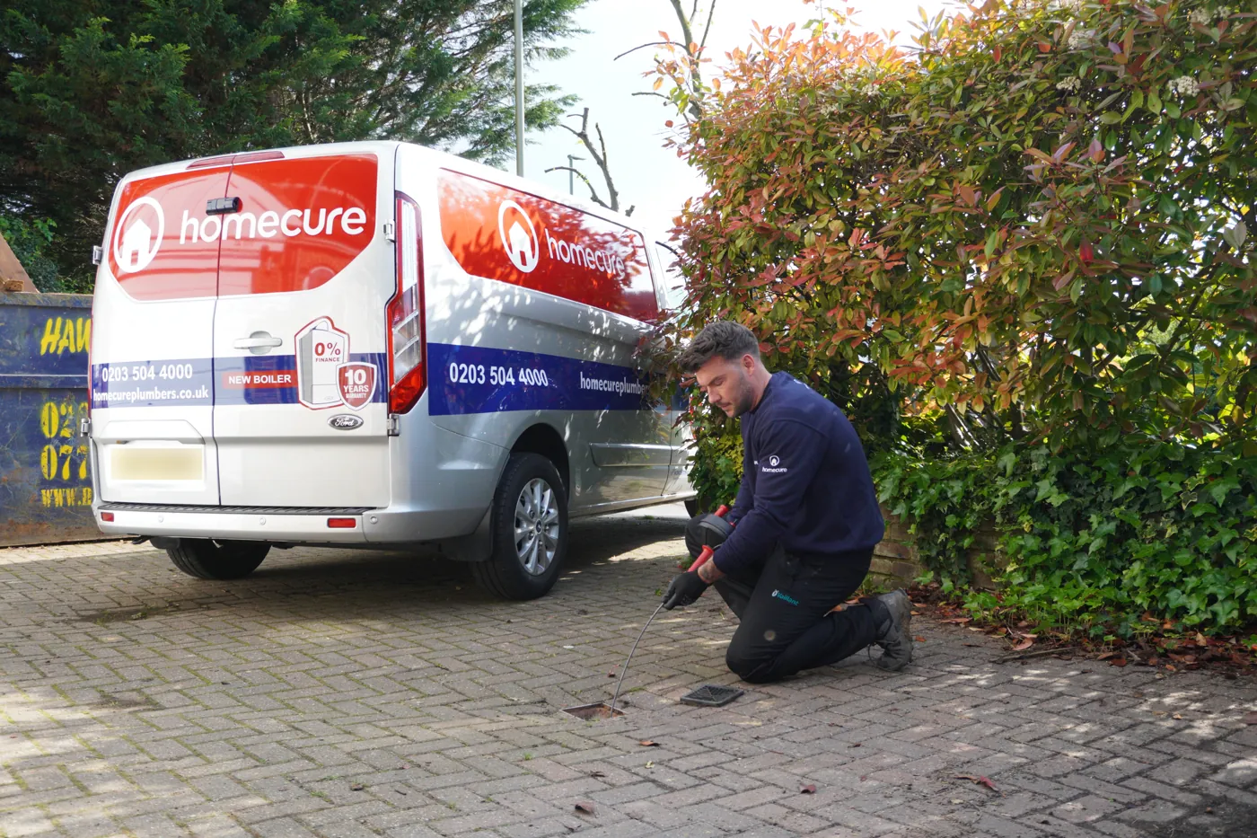 A Homecure engineer rodding an outside gully on a driveway