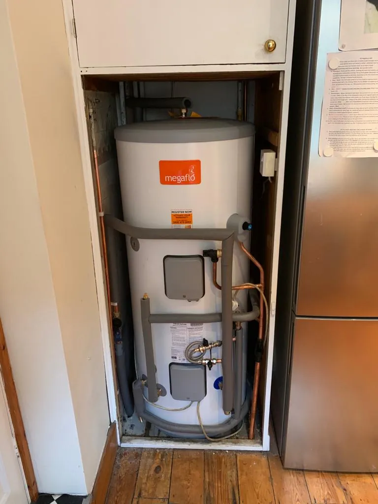 An unvented hot water cylinder installed in a cupboard